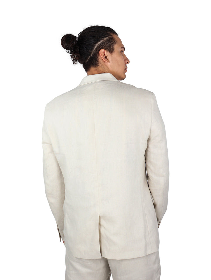 Hombre vistiendo un saco casual color beige con pantalones a juego y camisa de rayas.