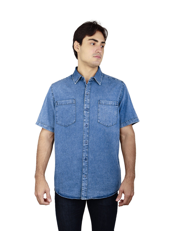 Hombre vistiendo una camisa de mezclilla azul stone con manga corta y dos bolsillos en el pecho.