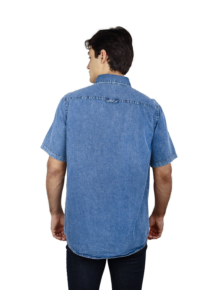 Hombre vistiendo una camisa de mezclilla azul stone con manga corta y dos bolsillos en el pecho.