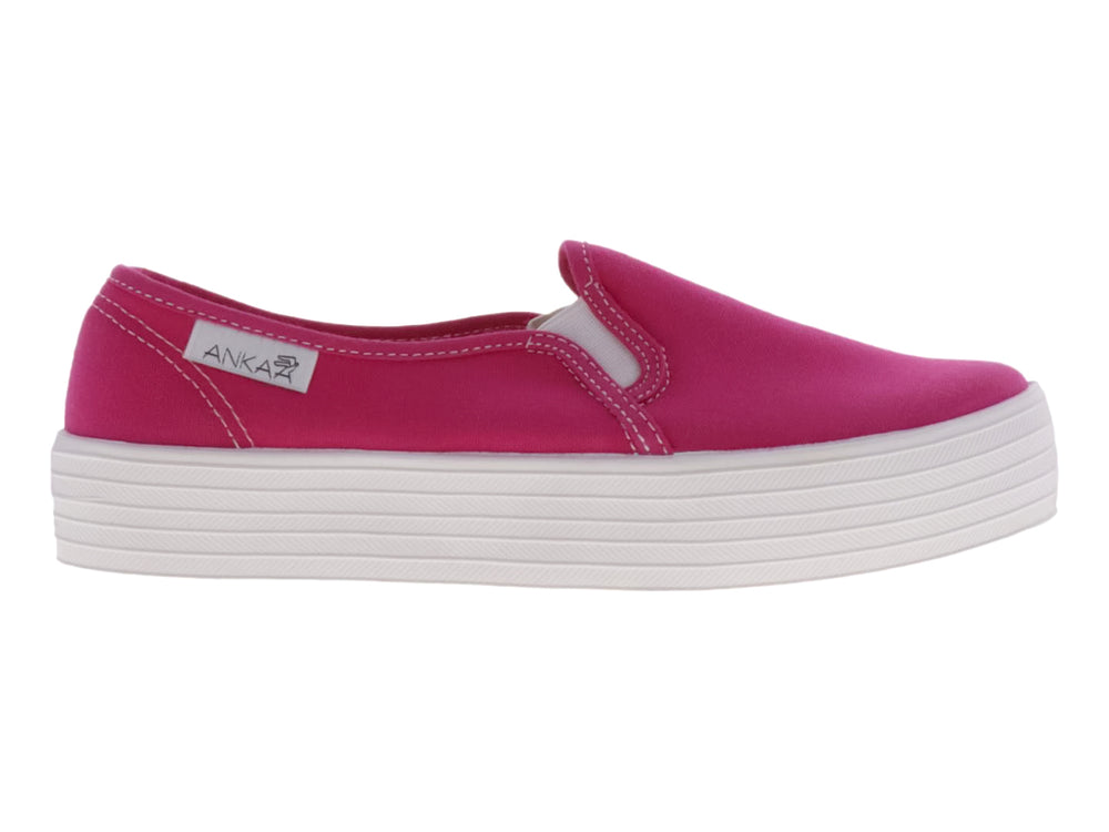 Tenis slip-on de color fucsia con suela de plataforma blanca ancha.