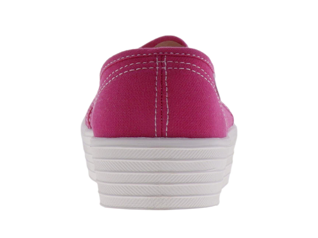 Tenis slip-on de color fucsia con suela de plataforma blanca ancha.