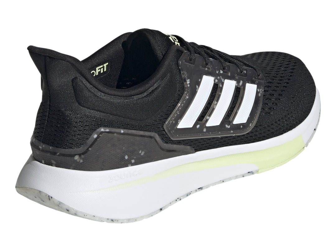 Tenis Adidas EQ21 en color negro con franjas blancas y detalles en lima sobre fondo blanco.