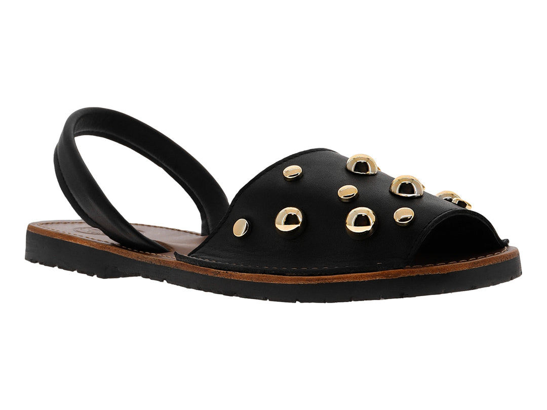 Sandalia menorquina negra para mujer con detalles de tachuelas doradas y suela plana.