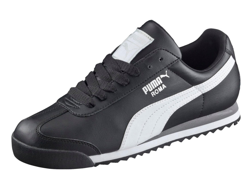 Tenis Puma Roma Basic color negro con franja blanca lateral y suela blanca y gris.