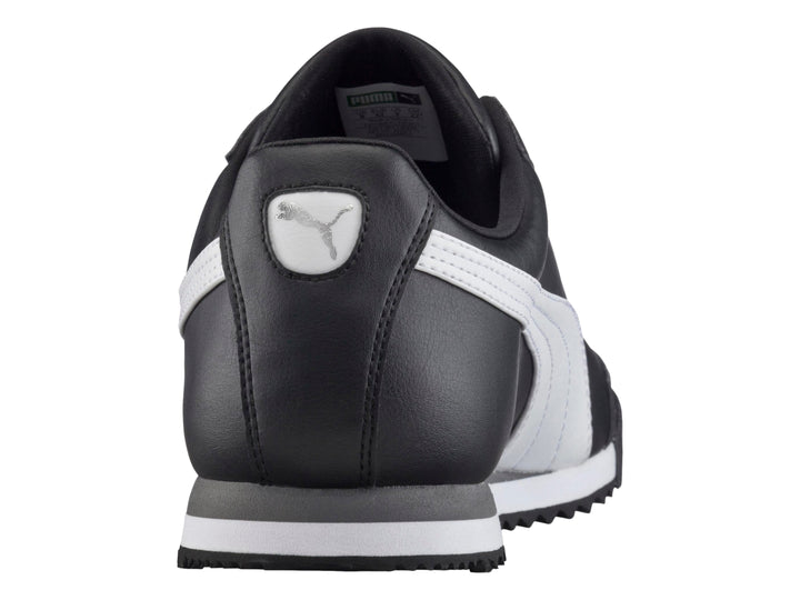 Tenis Puma Roma Basic color negro con franja blanca lateral y suela blanca y gris.