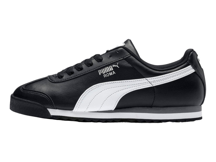 Tenis Puma Roma Basic color negro con franja blanca lateral y suela blanca y gris.