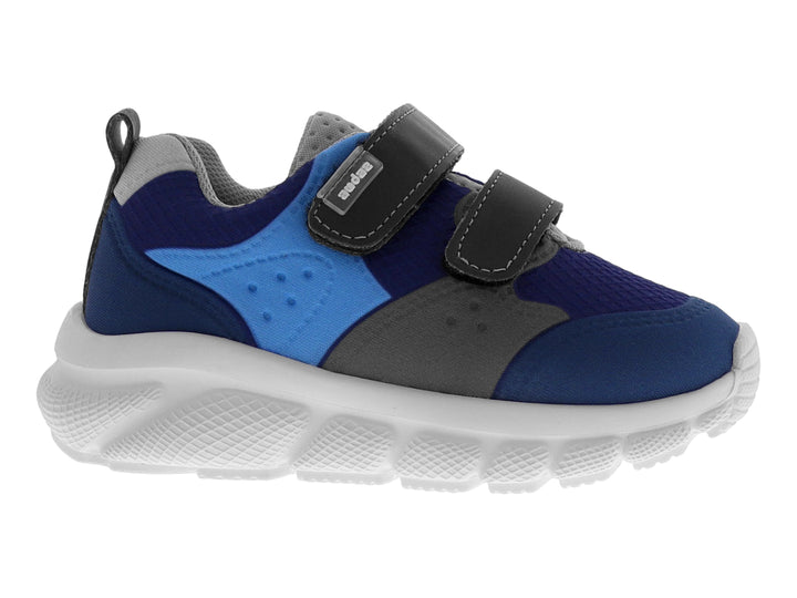 Tenis deportivo infantil en tonos azul y gris con cierre de velcro y suela blanca.