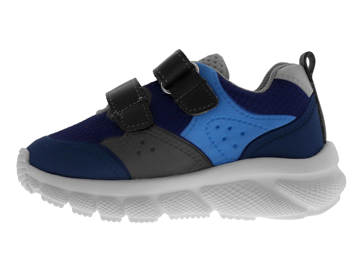 Tenis deportivo infantil en tonos azul y gris con cierre de velcro y suela blanca.