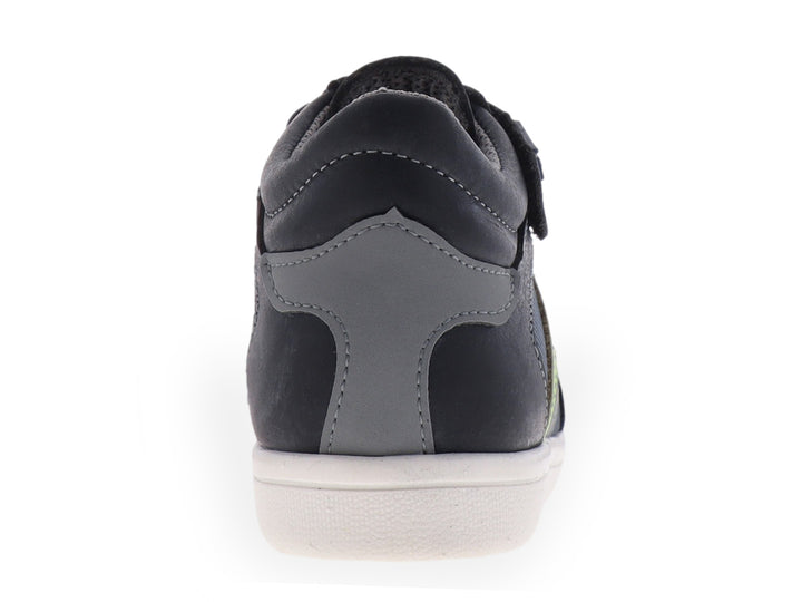 Tenis infantiles color azul con suela blanca y detalles laterales en verde y gris.