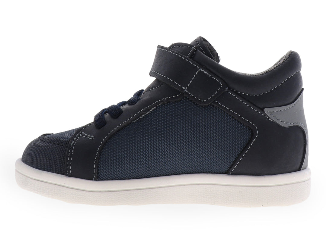 Tenis infantiles color azul con suela blanca y detalles laterales en verde y gris.