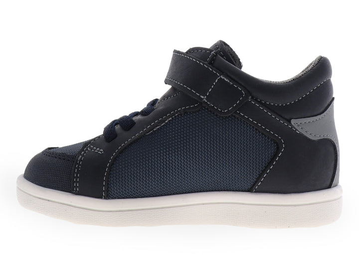 Tenis infantiles color azul con suela blanca y detalles laterales en verde y gris.