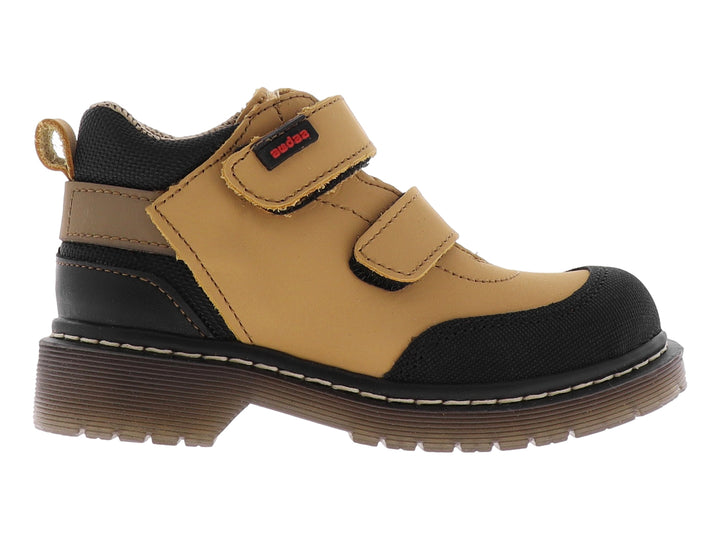Botas infantiles color miel con punta y suela negra, cierre de doble correa con velcro.