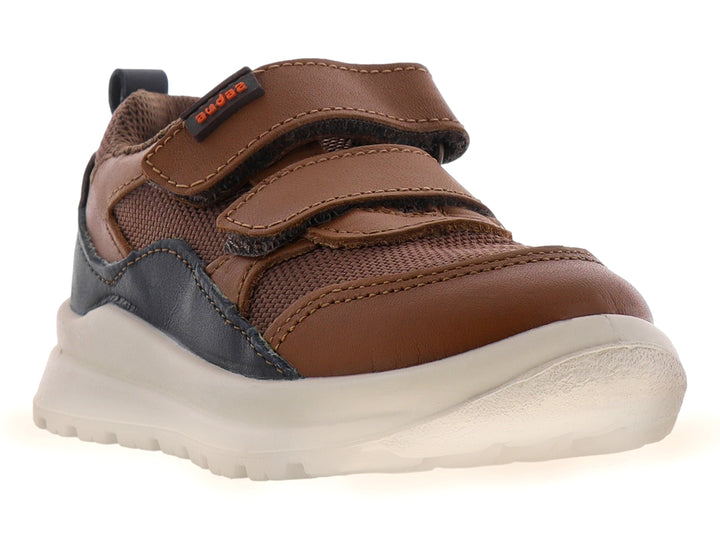 Zapato casual para niño en color miel con detalles en negro, cierre de velcro y suela blanca.