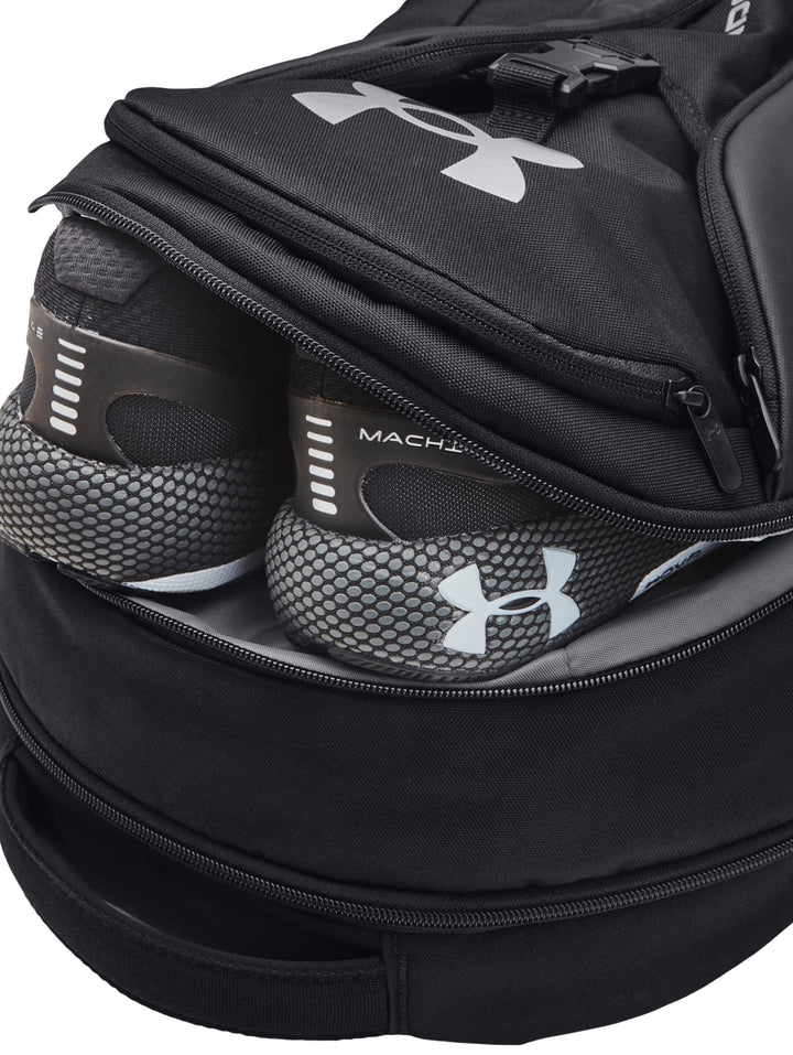 Mochila Under Armour Hustle Pro en color negro con logotipo plateado y diseño deportivo.