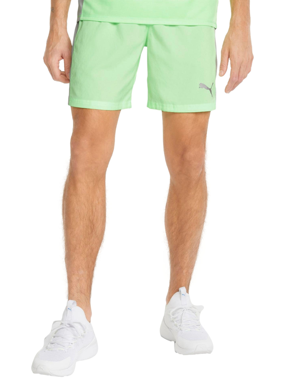 Hombre vistiendo shorts deportivos PUMA color verde lima con logo blanco en la pierna izquierda.
