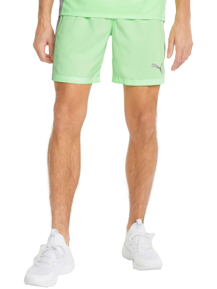 Hombre vistiendo shorts deportivos PUMA color verde lima con logo blanco en la pierna izquierda.