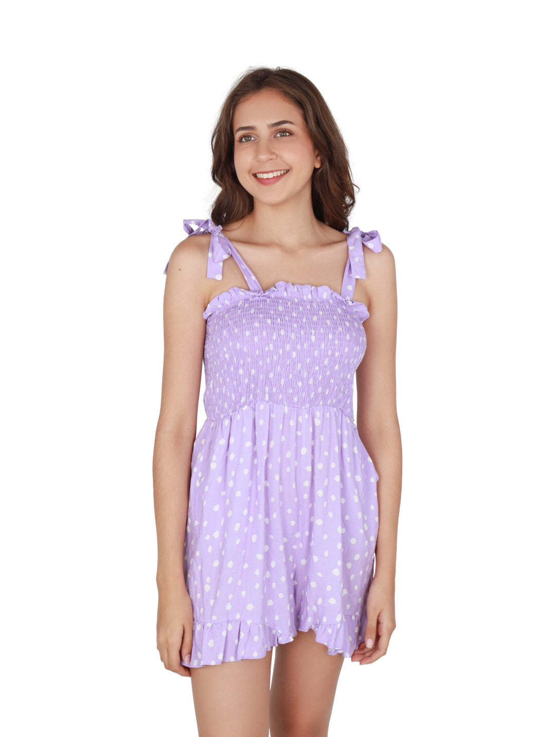 Mujer vistiendo un romper corto color lila con lunares blancos y tirantes ajustables.