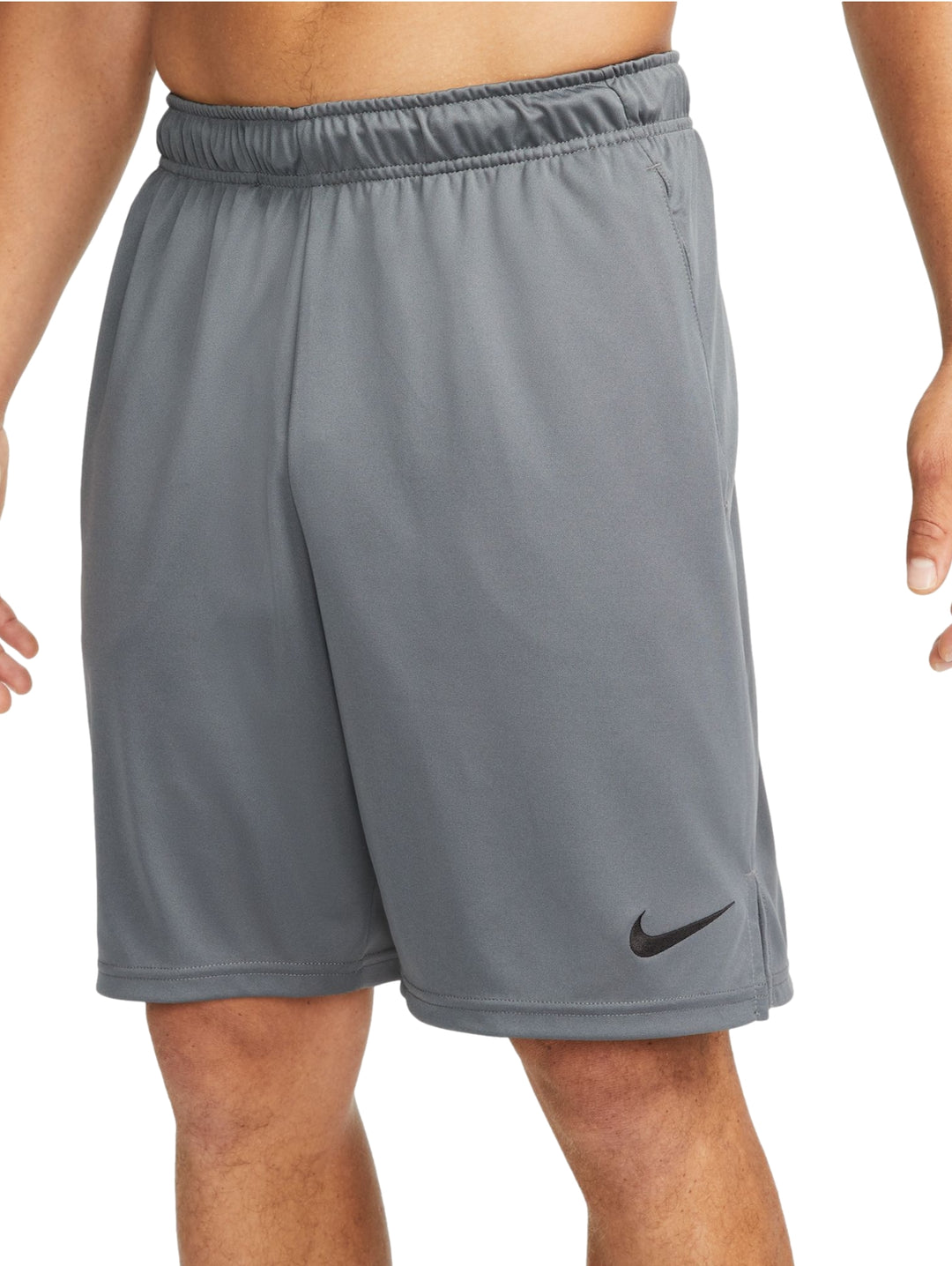 Hombre vistiendo shorts deportivos Nike color gris con logotipo negro.