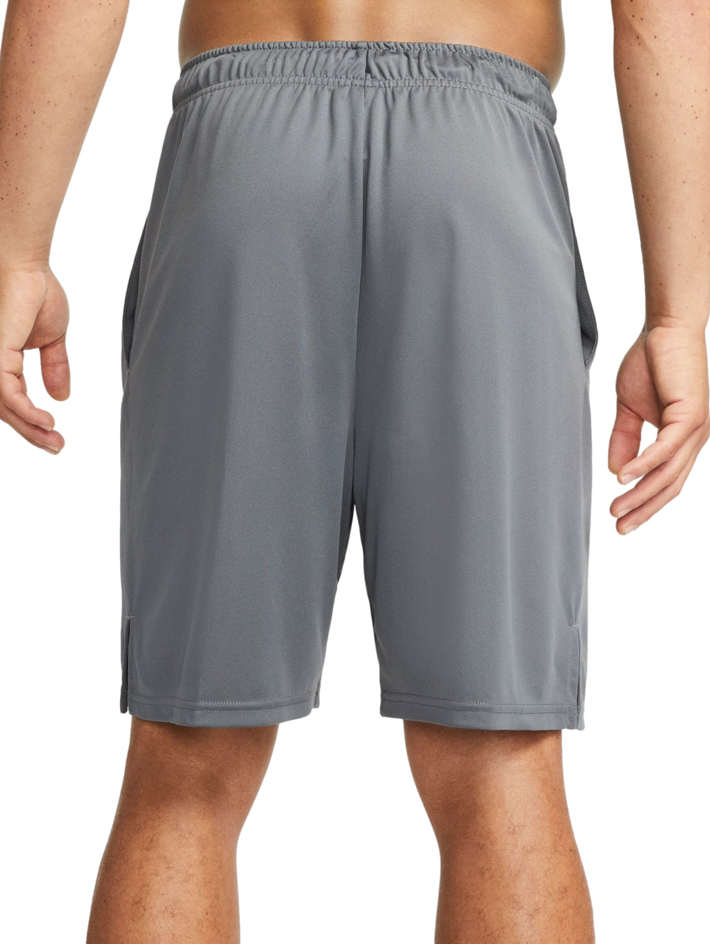 Hombre vistiendo shorts deportivos Nike color gris con logotipo negro.
