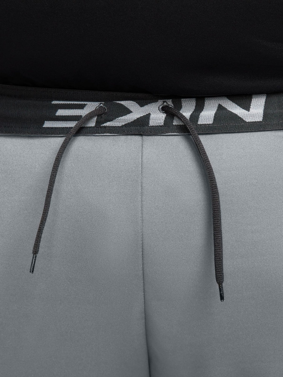 Hombre vistiendo shorts deportivos Nike color gris con logotipo negro.