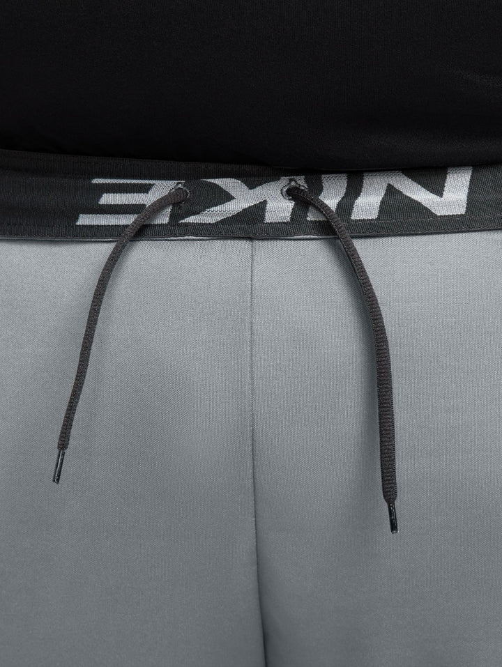 Hombre vistiendo shorts deportivos Nike color gris con logotipo negro.