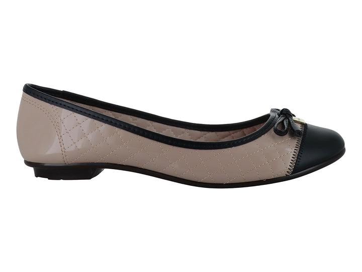 Zapato plano tipo ballerina para mujer en color beige con textura acolchada y punta negra con un pequeño moño.