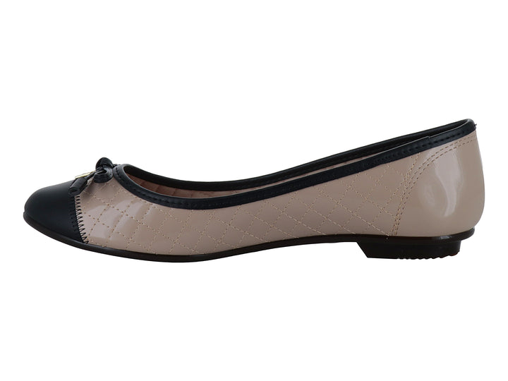 Zapato plano tipo ballerina para mujer en color beige con textura acolchada y punta negra con un pequeño moño.