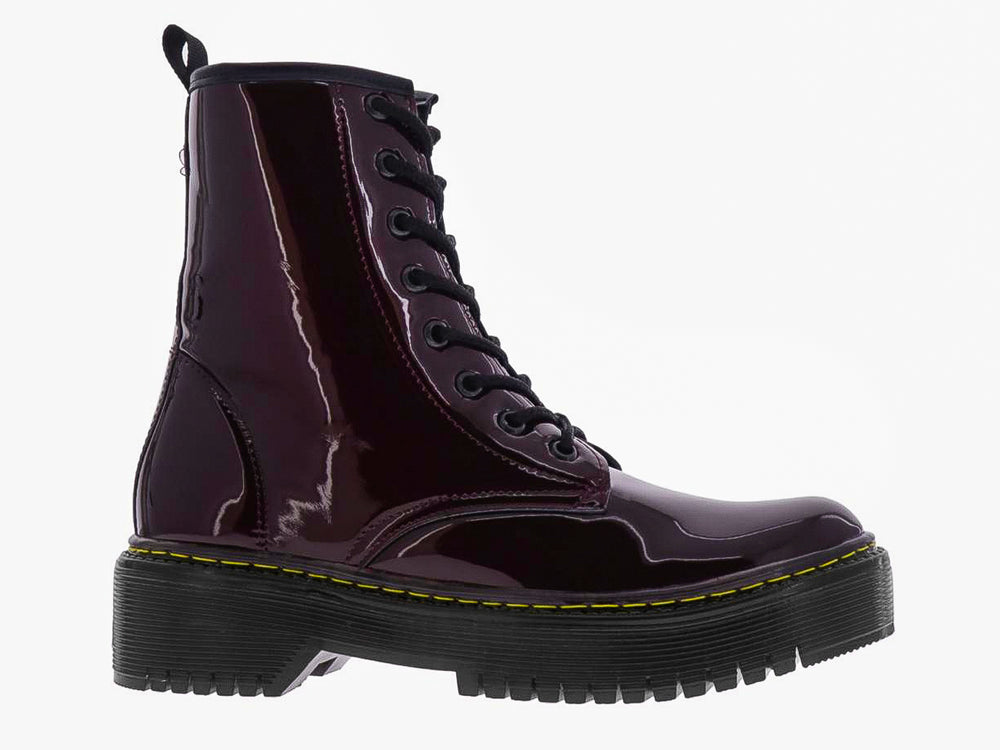 Botas de charol color merlot con cordones negros y suela gruesa de plataforma negra con costura amarilla.