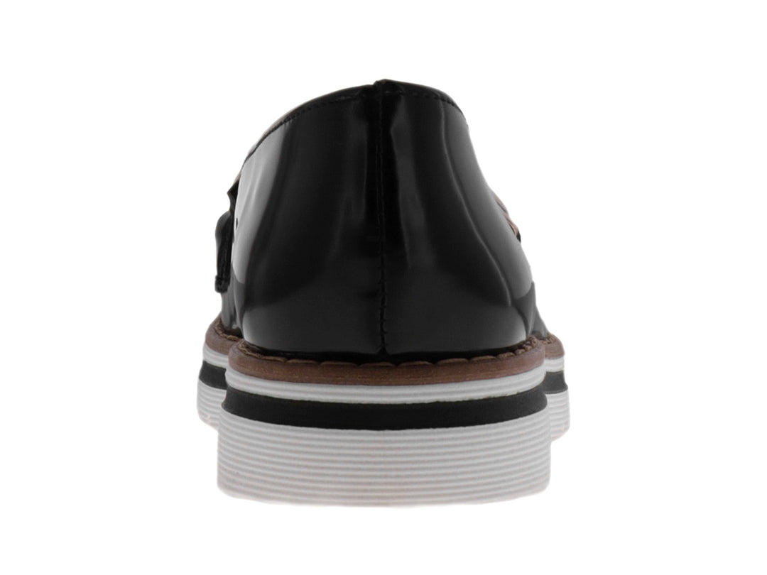 Mocasín negro brillante con suela blanca de plataforma y detalle de cadena dorada.