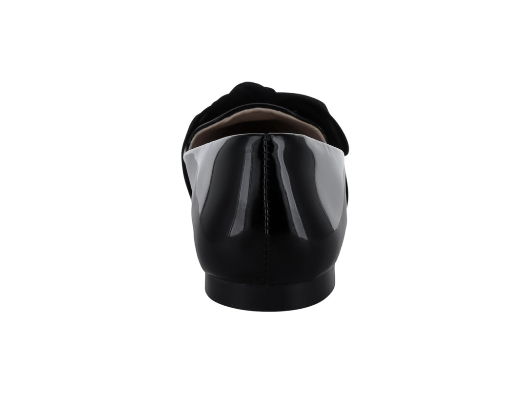 Zapato plano negro de charol con un moño decorativo en la parte superior.