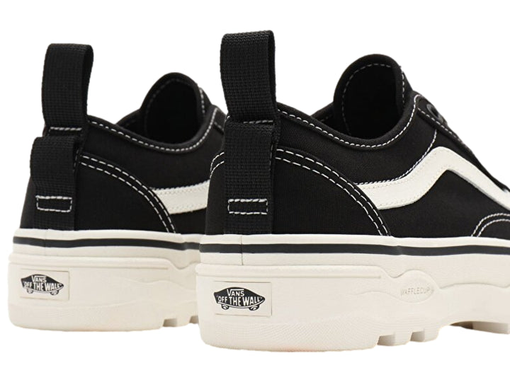 Tenis Vans Old Skool en color negro con franja y suela plataforma blanca.