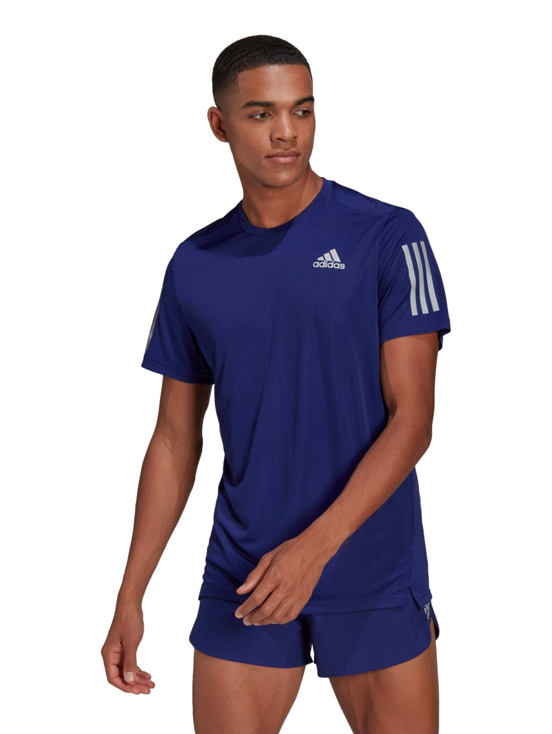 Hombre vistiendo camiseta deportiva Adidas color azul índigo con detalles plateados en los hombros.