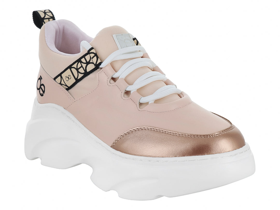 Tenis Cloe color nude con suela blanca de plataforma y punta dorada metálica.