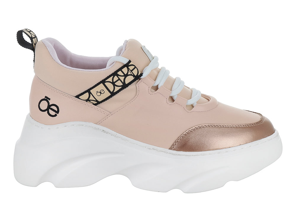 Tenis Cloe color nude con suela blanca de plataforma y punta dorada metálica.