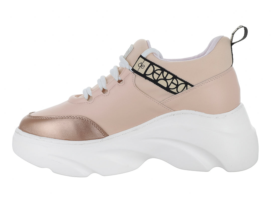Tenis Cloe color nude con suela blanca de plataforma y punta dorada metálica.