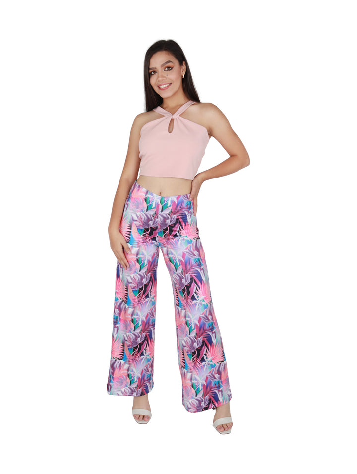 Mujer vistiendo un crop top color rosa con cuello halter y detalle de nudo al frente.