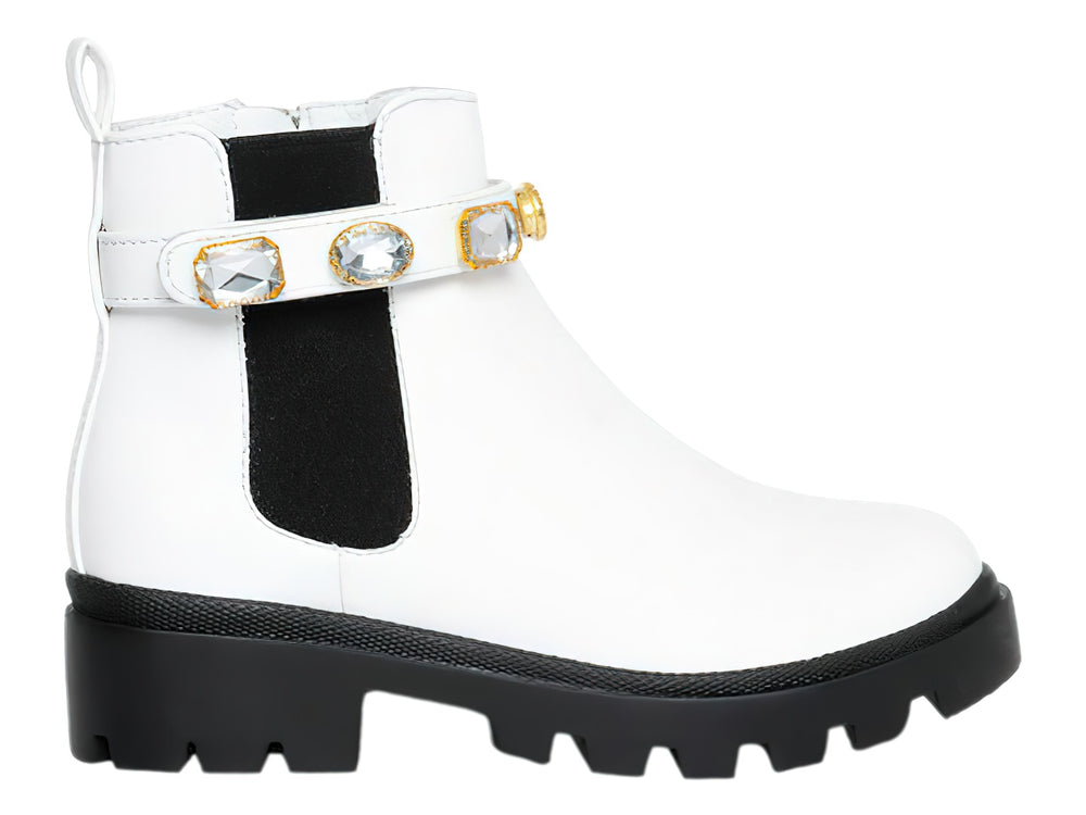 Bota blanca de tobillo con suela negra track y correa decorada con cristales.