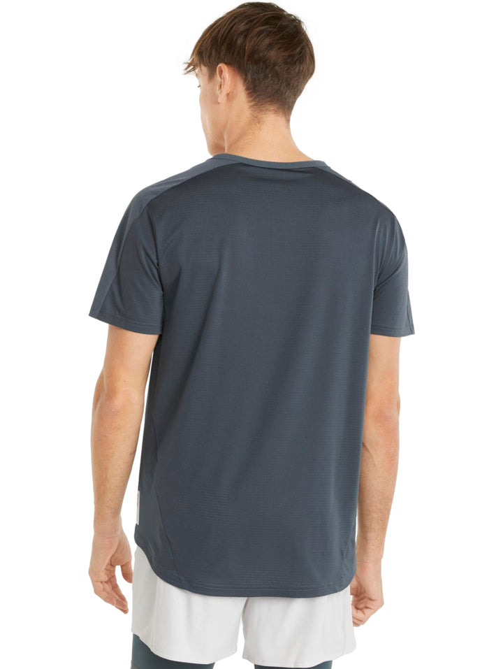 Hombre vistiendo una camiseta deportiva PUMA de color gris oscuro y shorts blancos.