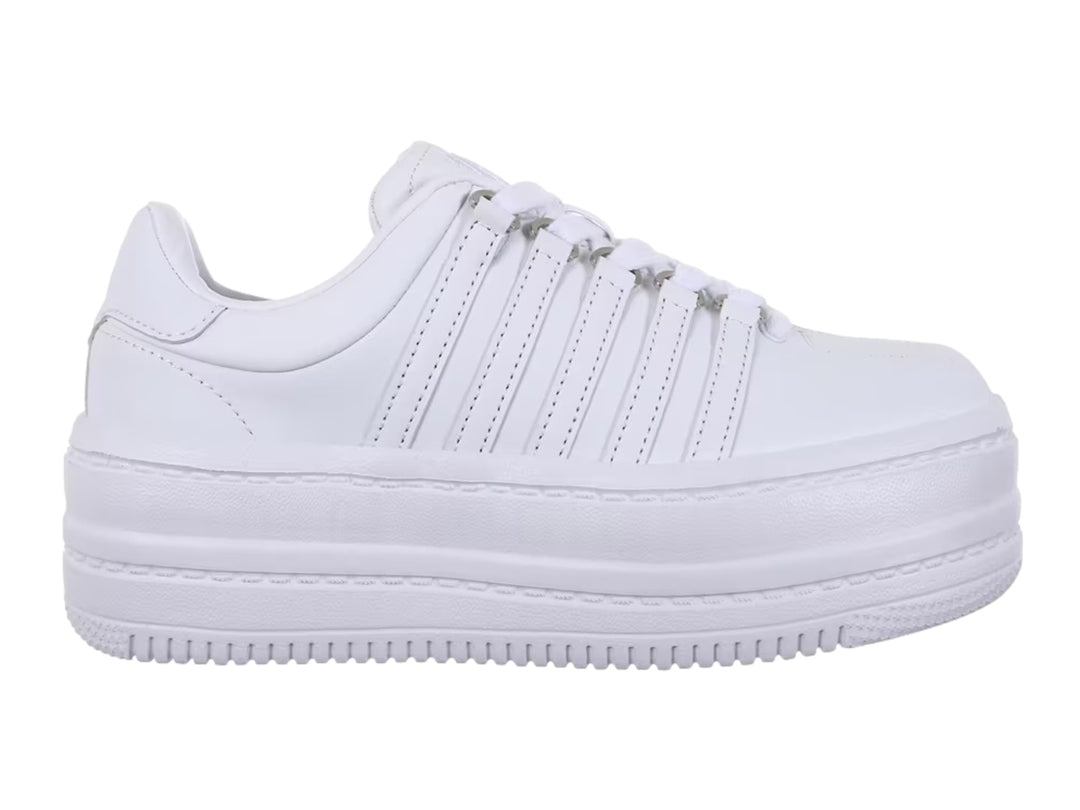 Tenis K-Swiss blancos de plataforma con suela gruesa y diseño clásico de rayas laterales.