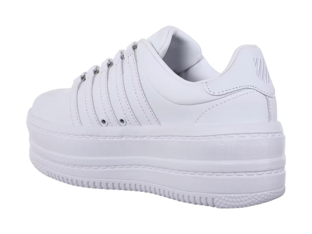 Tenis K-Swiss blancos de plataforma con suela gruesa y diseño clásico de rayas laterales.