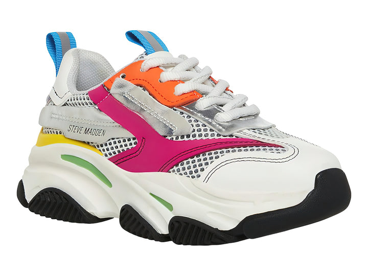 Tenis deportivos Steve Madden para niños en color blanco con detalles multicolores y suela chunky negra.