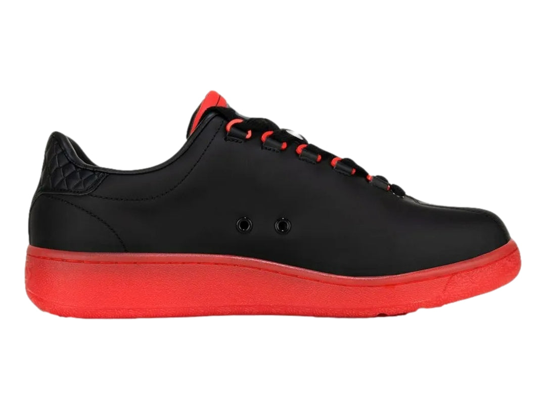 Tenis K-Swiss modelo Classic VN en color negro con suela y agujetas en color rojo intenso.
