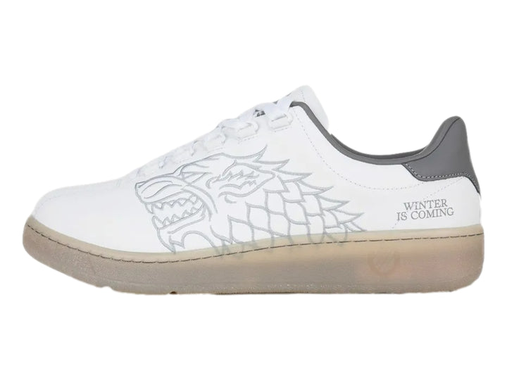 Tenis K-Swiss blancos con detalle gris en el talón y suela translúcida beige.