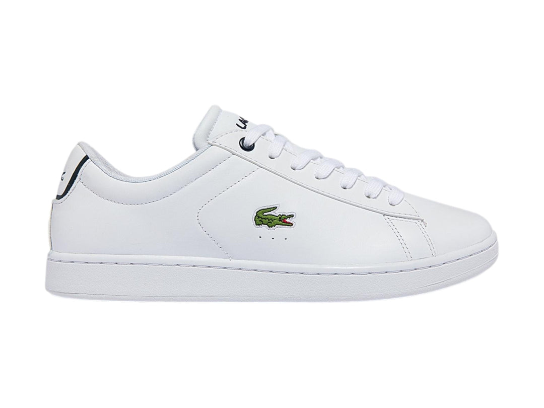 Tenis blancos de cuero marca Lacoste con logotipo del cocodrilo verde y detalle azul marino en el talón.