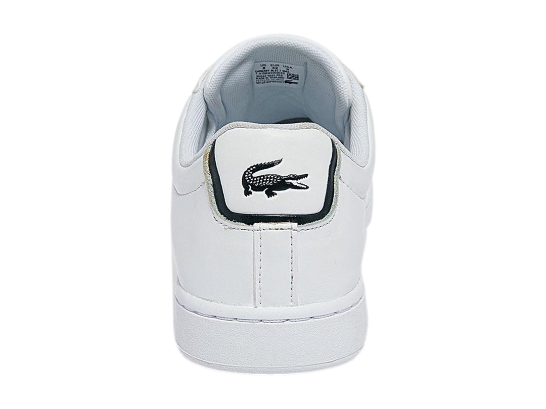 Tenis blancos de cuero marca Lacoste con logotipo del cocodrilo verde y detalle azul marino en el talón.