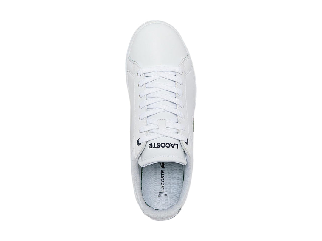 Tenis blancos de cuero marca Lacoste con logotipo del cocodrilo verde y detalle azul marino en el talón.