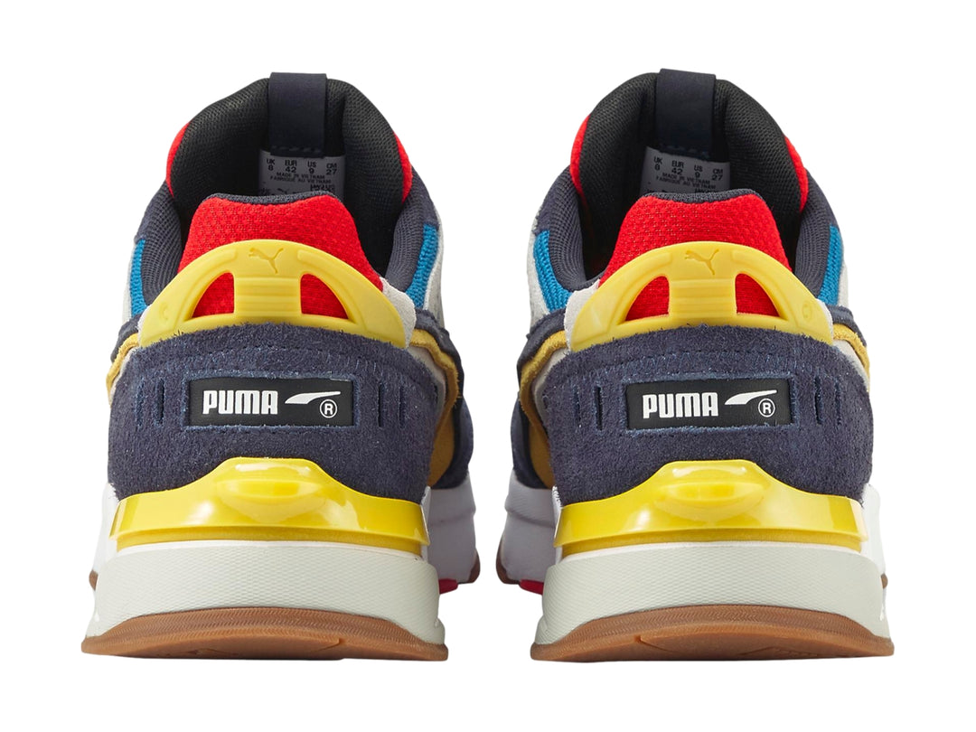 Tenis PUMA Mirage Sport Layers multicolor con detalles en azul, amarillo y rojo sobre suela blanca.