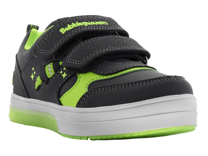 Tenis infantiles color gris con detalles en verde neón, cierre de velcro y diseño de cohete lateral.