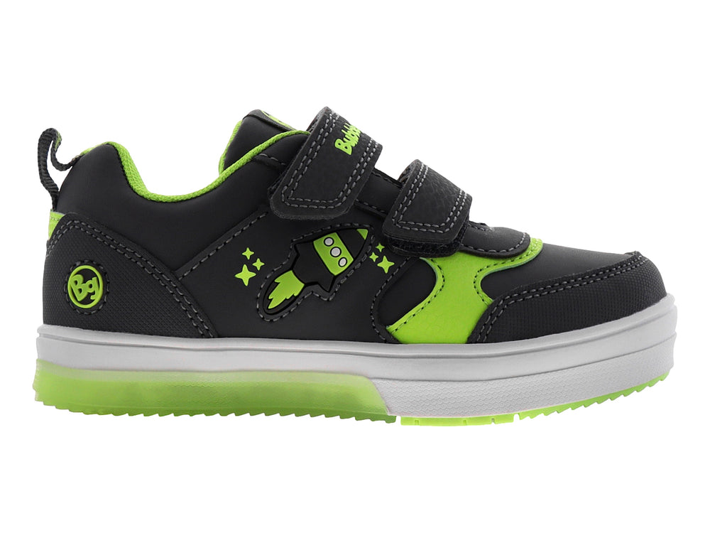 Tenis infantiles color gris con detalles en verde neón, cierre de velcro y diseño de cohete lateral.