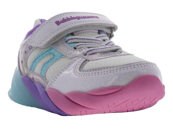 Tenis deportivos infantiles color plata con suela en tonos rosa, morado y azul.